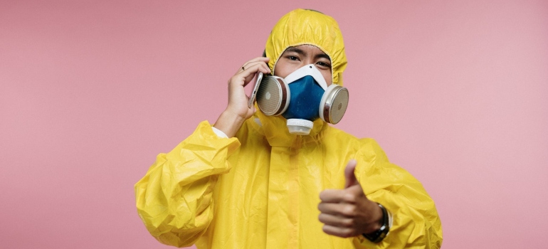 A person in a yellow protective suit giving advice about best bird deterrents in 2022 over the phone.