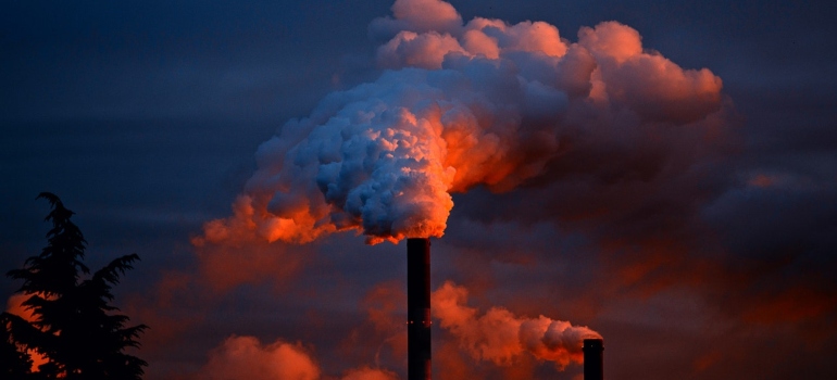 Industrial chimney producing a cloud of smoke.