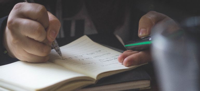 person writing down ideas in a notepad