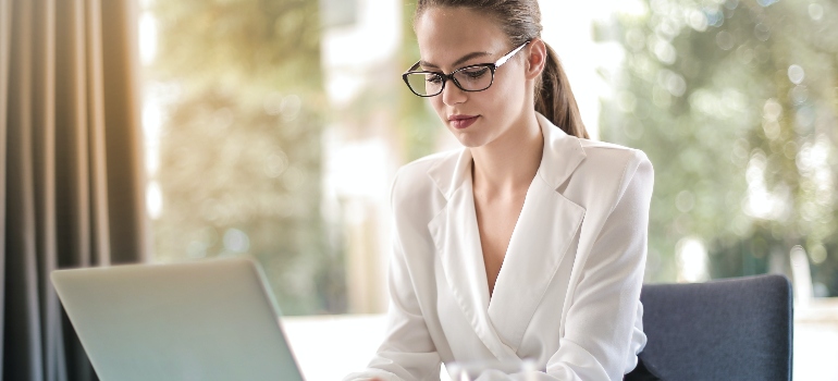 a woman looking on her laptop how to choose the best artificial turf