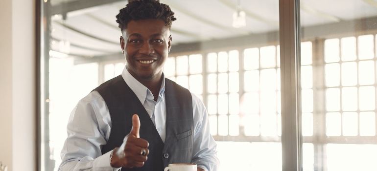 A young businessman giving thumbs up.