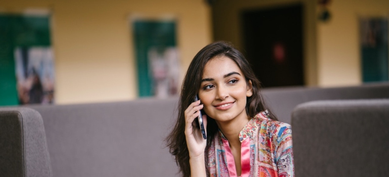 A smiling woman using phone to find the best solar panel companies in Nevada.