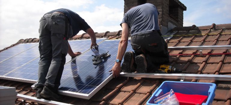 two men installing panels on a roof