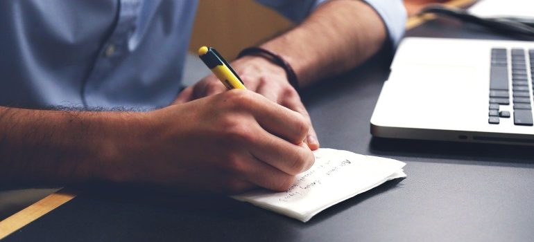 A man writing in a notebook about off-grid solar systems.