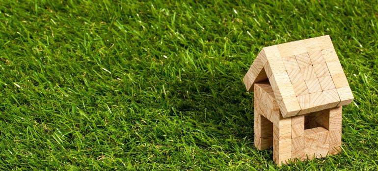 A model of a house on fake grass.