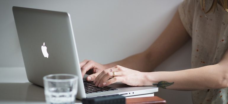 A woman researching how to choose the best artificial turf on her laptop.