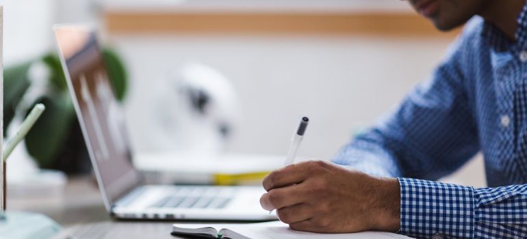 A man writing in a notebook.