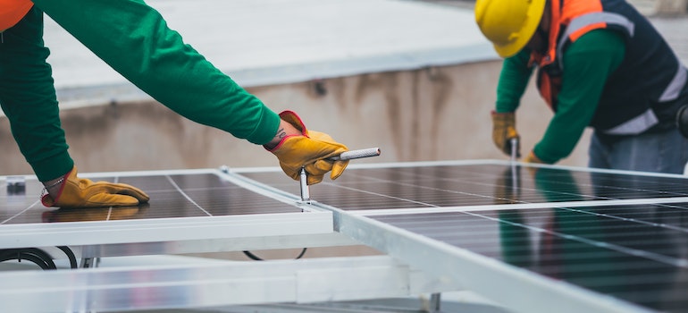 Two people installing solar panels