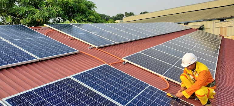 A worker checking the efficiency of solar panels as it is one of the things to know about installing solar panels on your roof