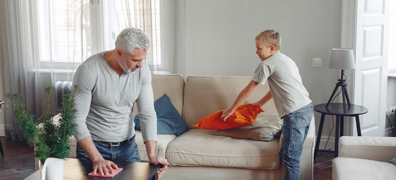 Two men cleaning living room as a symbol of how to deep-clean every room in your house