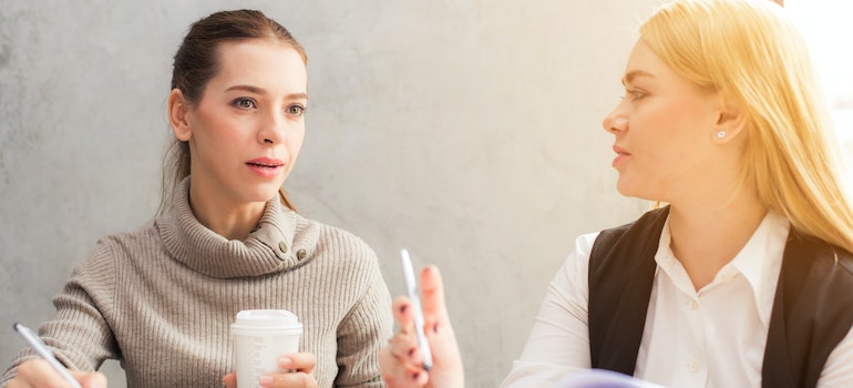 Two women talking about how to find the best pest control company in 2023