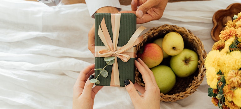 A person handing another person a gift as an example of what to do with extra artificial turf