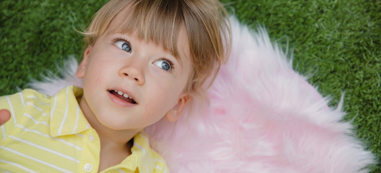 A kid lying on a carpet